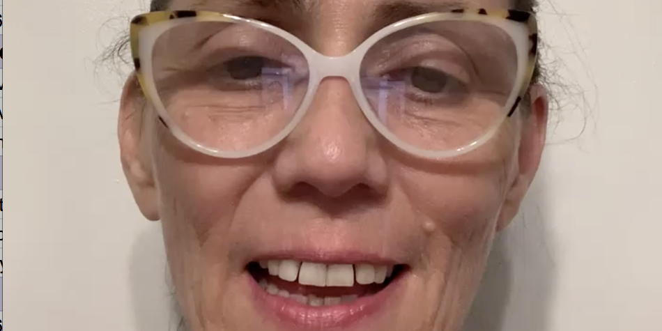 A woman with glasses smiling for the camera.